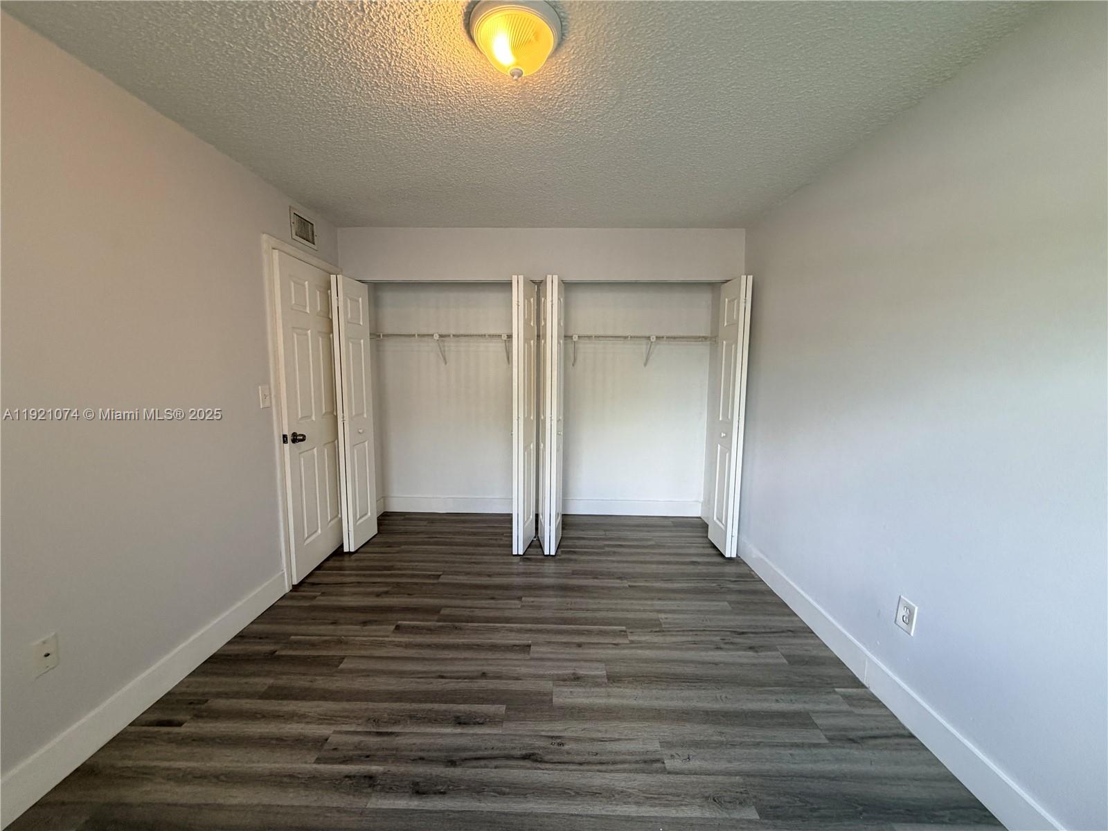 10350 Southwest 220th Street, Unit 143 Cutler Bay, FL 33190 - Photo 15 of 18 a view of an empty room with wooden floor