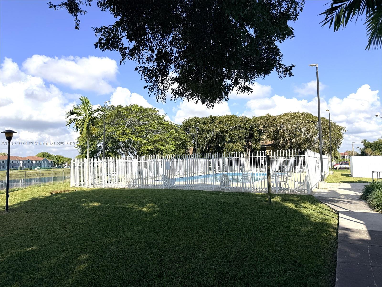 10350 Southwest 220th Street, Unit 143 Cutler Bay, FL 33190 - Photo 5 of 18 a view of yard with swimming pool and green space