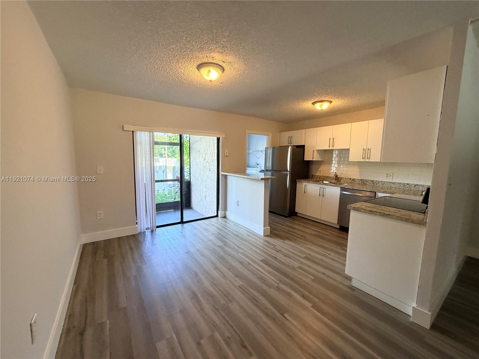 10350 Southwest 220th Street, Unit 143 Cutler Bay, FL 33190 - Photo 10 of 18 a view of a kitchen with refrigerator and wooden floor