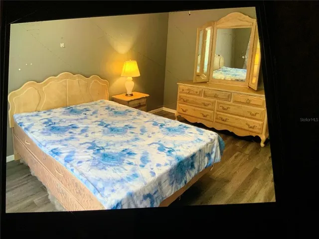 a bedroom with a bed and painting on the wall