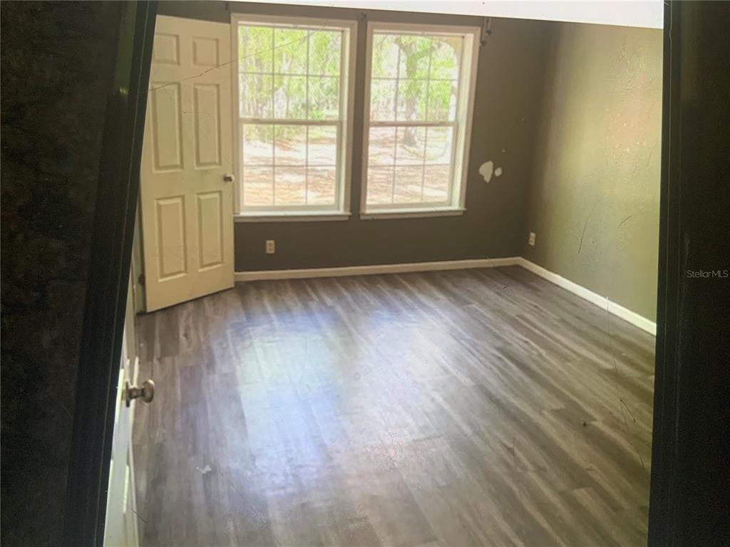 13080 Northwest 168th Place Reddick, FL 32686 - Photo 17 of 19 an empty room with wooden floor and windows