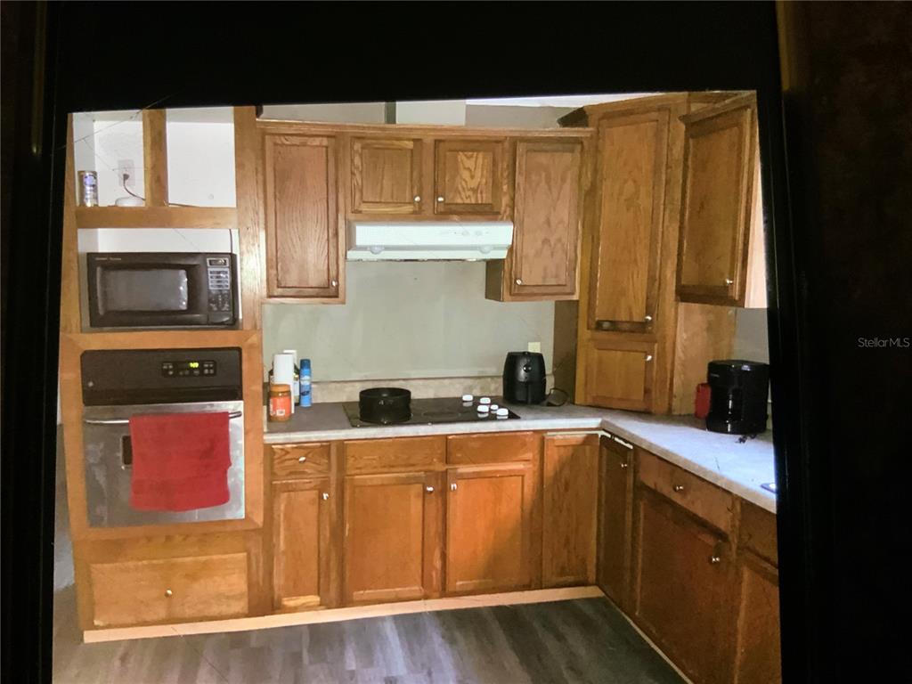13080 Northwest 168th Place Reddick, FL 32686 - Photo 6 of 19 a kitchen with a sink a stove cabinets and wooden floor