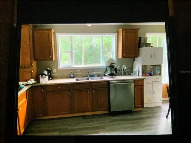 a kitchen with a sink cabinets and a large window