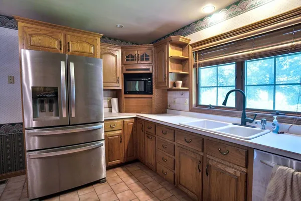 a kitchen with stainless steel appliances granite countertop a sink and a refrigerator