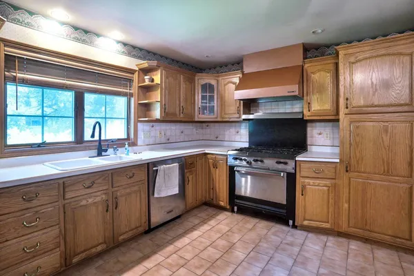 a kitchen with stainless steel appliances granite countertop a sink stove and refrigerator