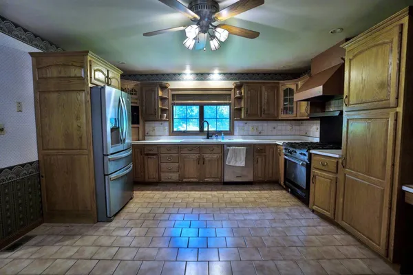 a kitchen with stainless steel appliances granite countertop a refrigerator and a sink