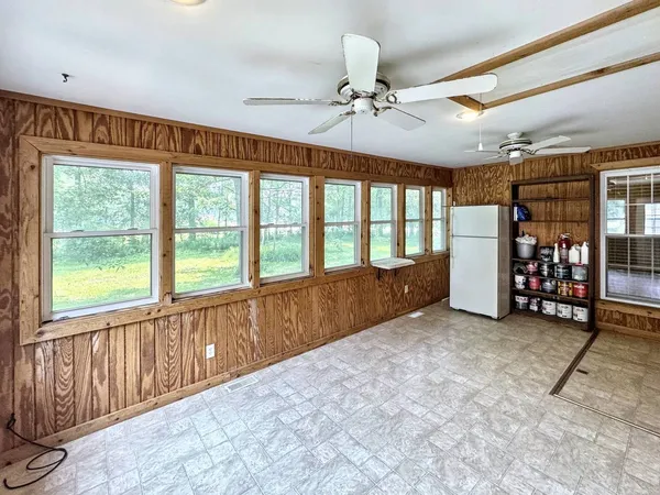 a view of an empty room with window and furniture