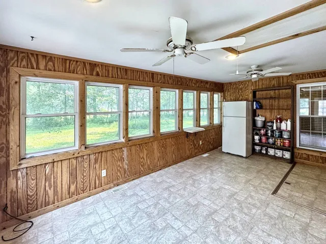 a view of an empty room with window and furniture
