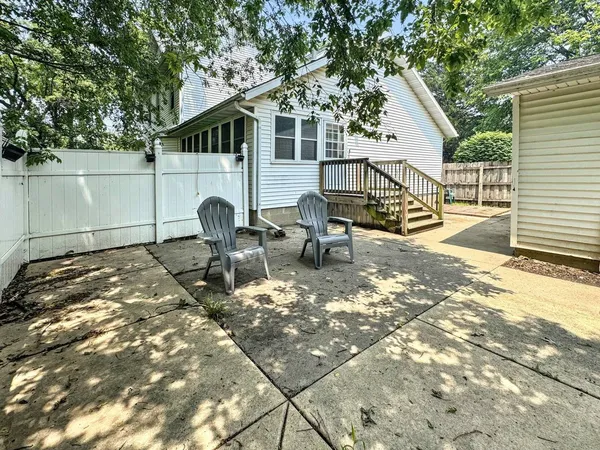 a backyard of a house with table and chairs