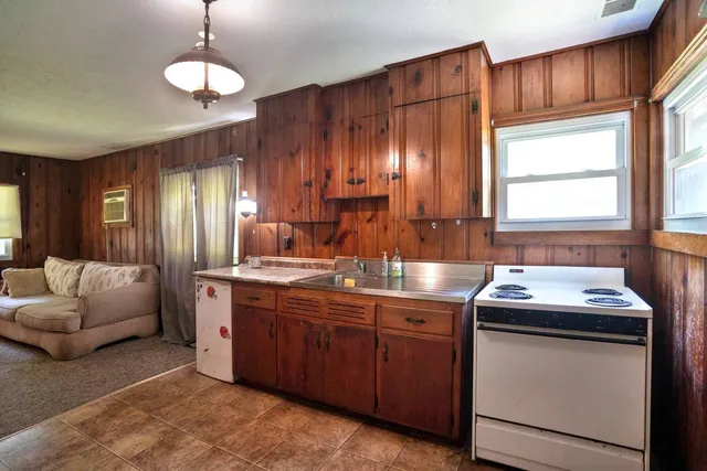 a kitchen with stainless steel appliances granite countertop a sink a stove and a refrigerator