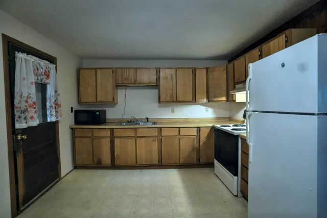 a view of an empty room with a fireplace and a window