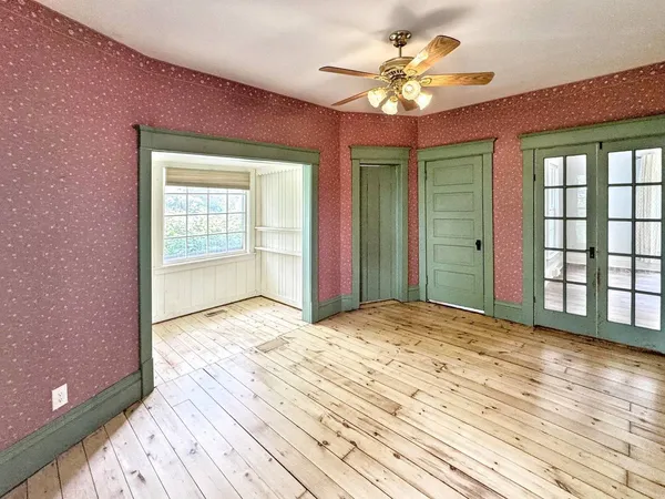 a view of a livingroom with a chandelier fan and windows