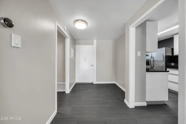 a view of a hallway with wooden floor and a kitchen