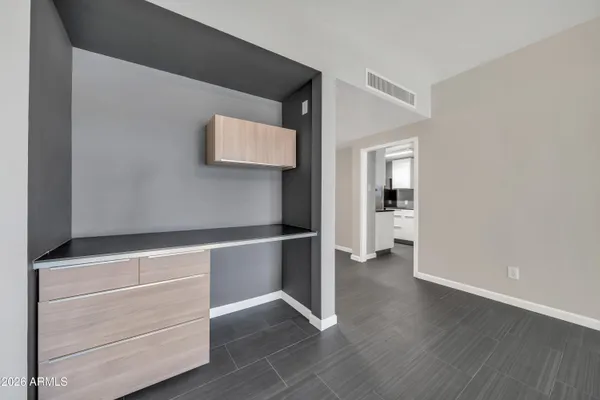 a kitchen with a refrigerator and white cabinets