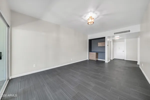 a view of empty room with wooden floor and window