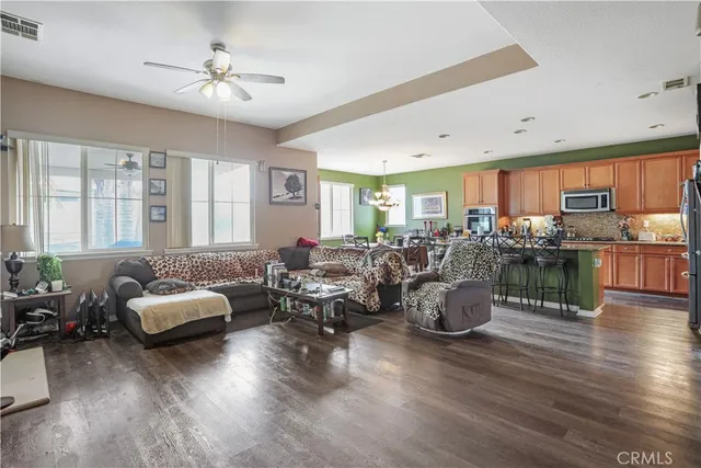 a living room with furniture kitchen view and a large window