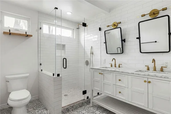 a bathroom with a granite countertop sink a toilet and a mirror