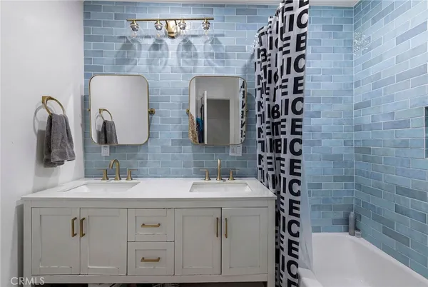 a bathroom with a double vanity sink mirror and shower