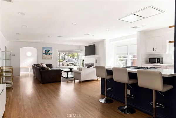 a living room with furniture floor to ceiling window and wooden floor