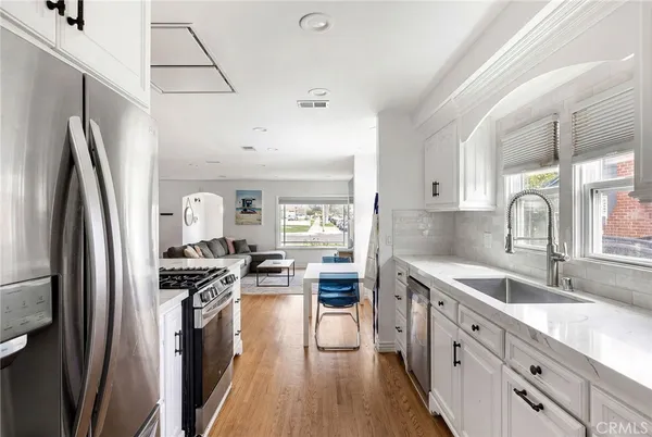 a kitchen with stainless steel appliances a sink stove refrigerator and cabinets