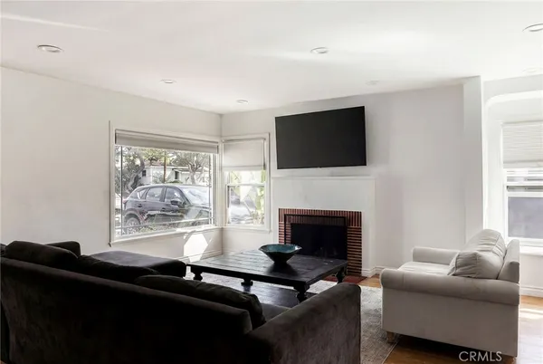 a living room with furniture a fireplace and a flat screen tv