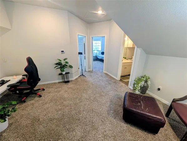 a living room with furniture plant and a window