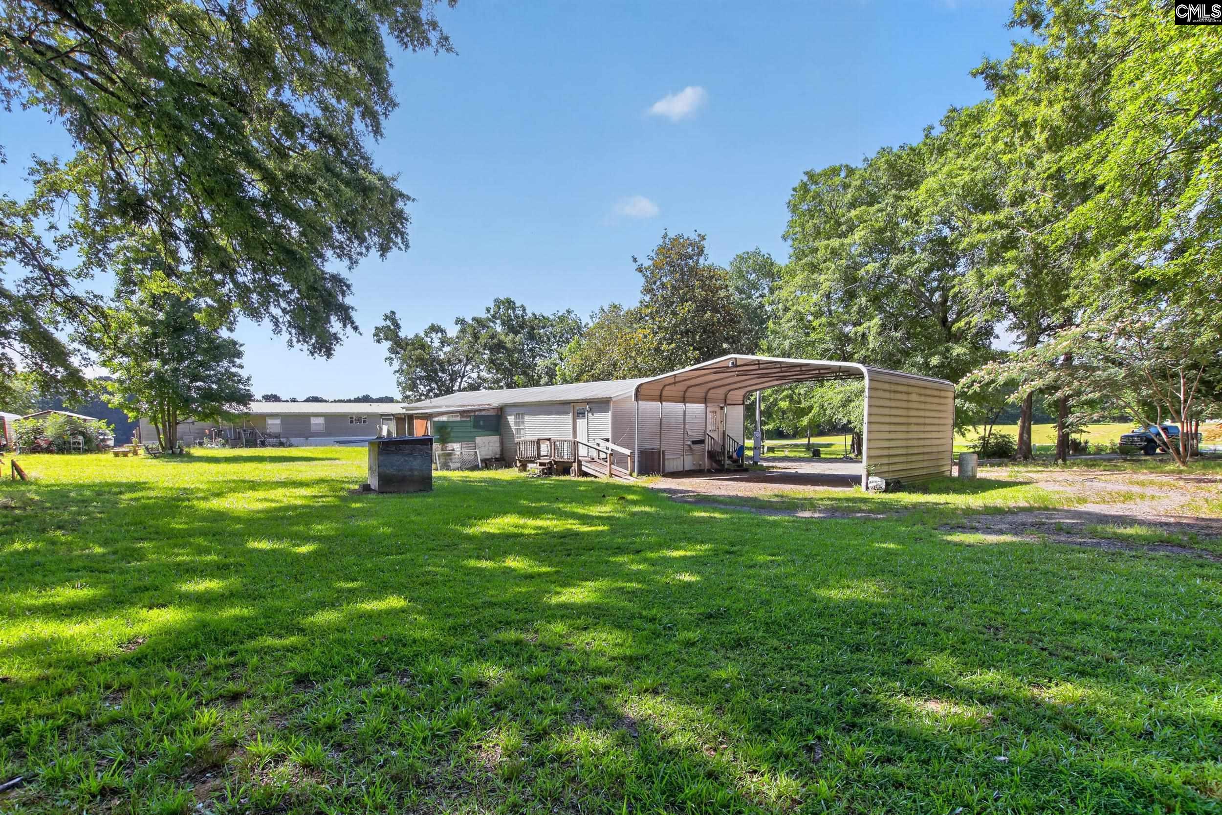 3140 Highway 702 Chappells, SC 29037 - Photo 25 of 39 a front view of a house with garden and trees