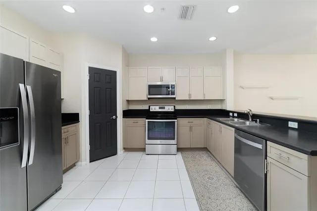 a kitchen with stainless steel appliances granite countertop a refrigerator and a stove