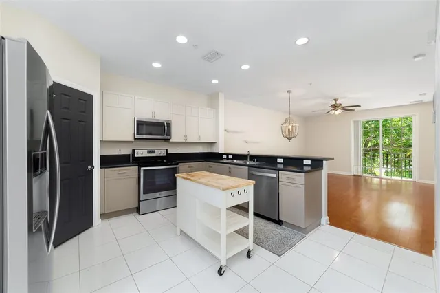 a kitchen with a refrigerator and a stove top oven