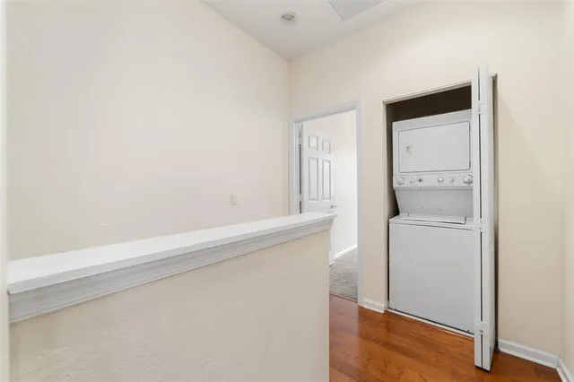 a utility room with wooden floor washer and dryer