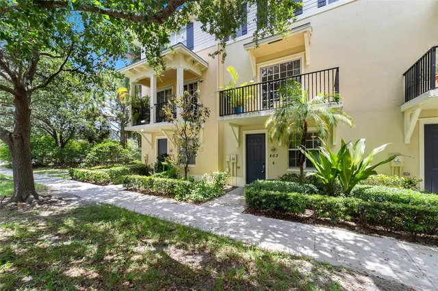 a front view of a house with a yard and potted plants