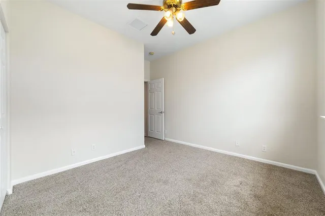 a view of a room with a ceiling fan and a window