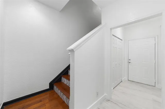 a view of staircase with wooden floor and white walls