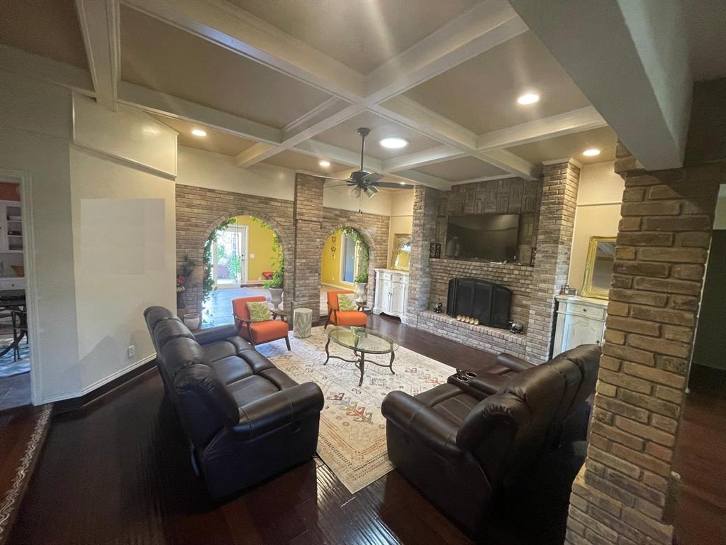 3612 Cross Bend Road Plano, TX 75023 - Photo 12 of 38 Living room featuring ceiling fan, beamed ceiling, a fireplace, dark wood-type flooring, and coffered ceiling
