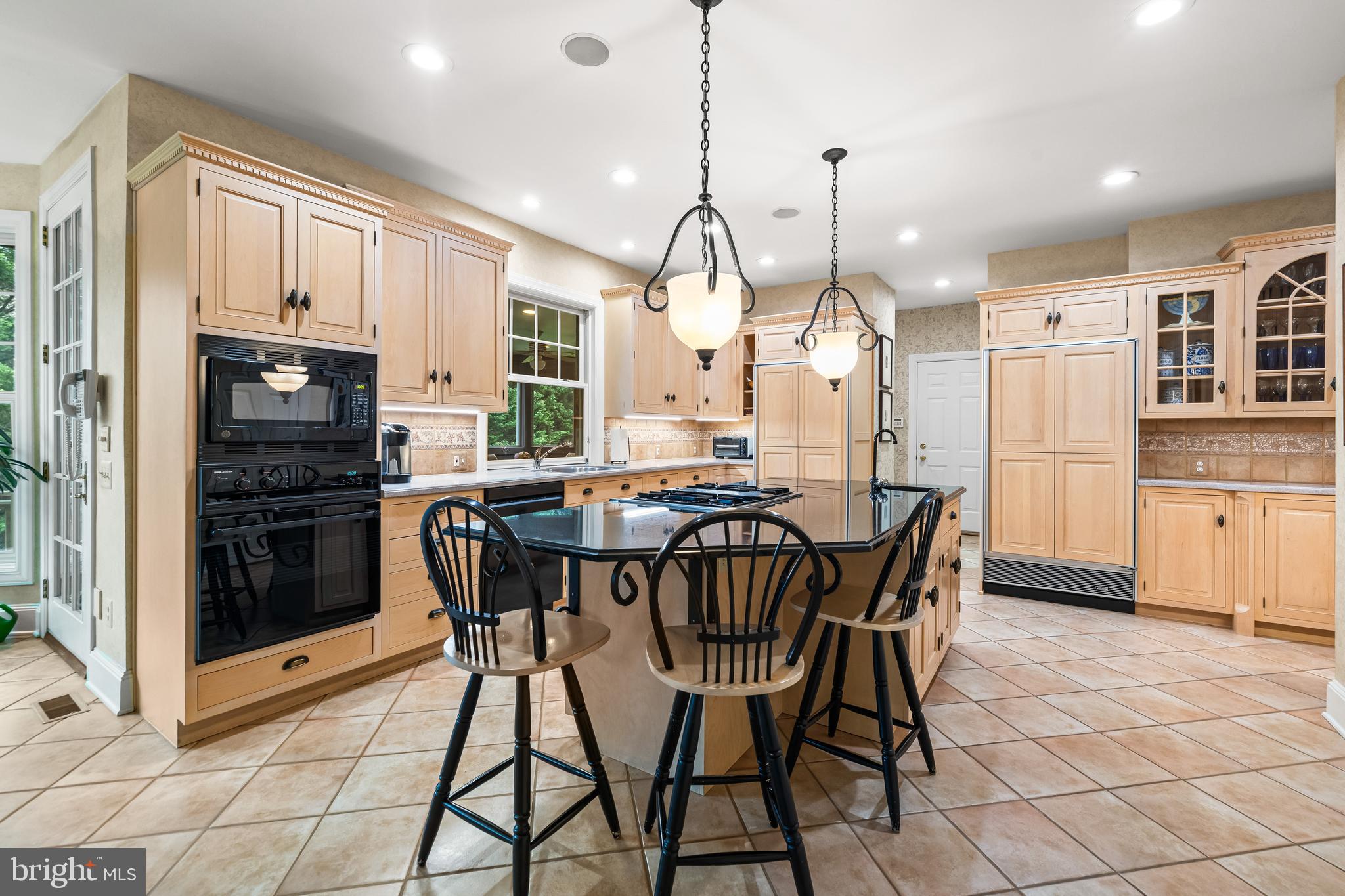 7 Hambleton Court Baltimore, MD 21208 - Photo 26 of 61 a kitchen with stainless steel appliances kitchen island granite countertop a refrigerator a stove a microwave oven a sink with a dining table and chairs