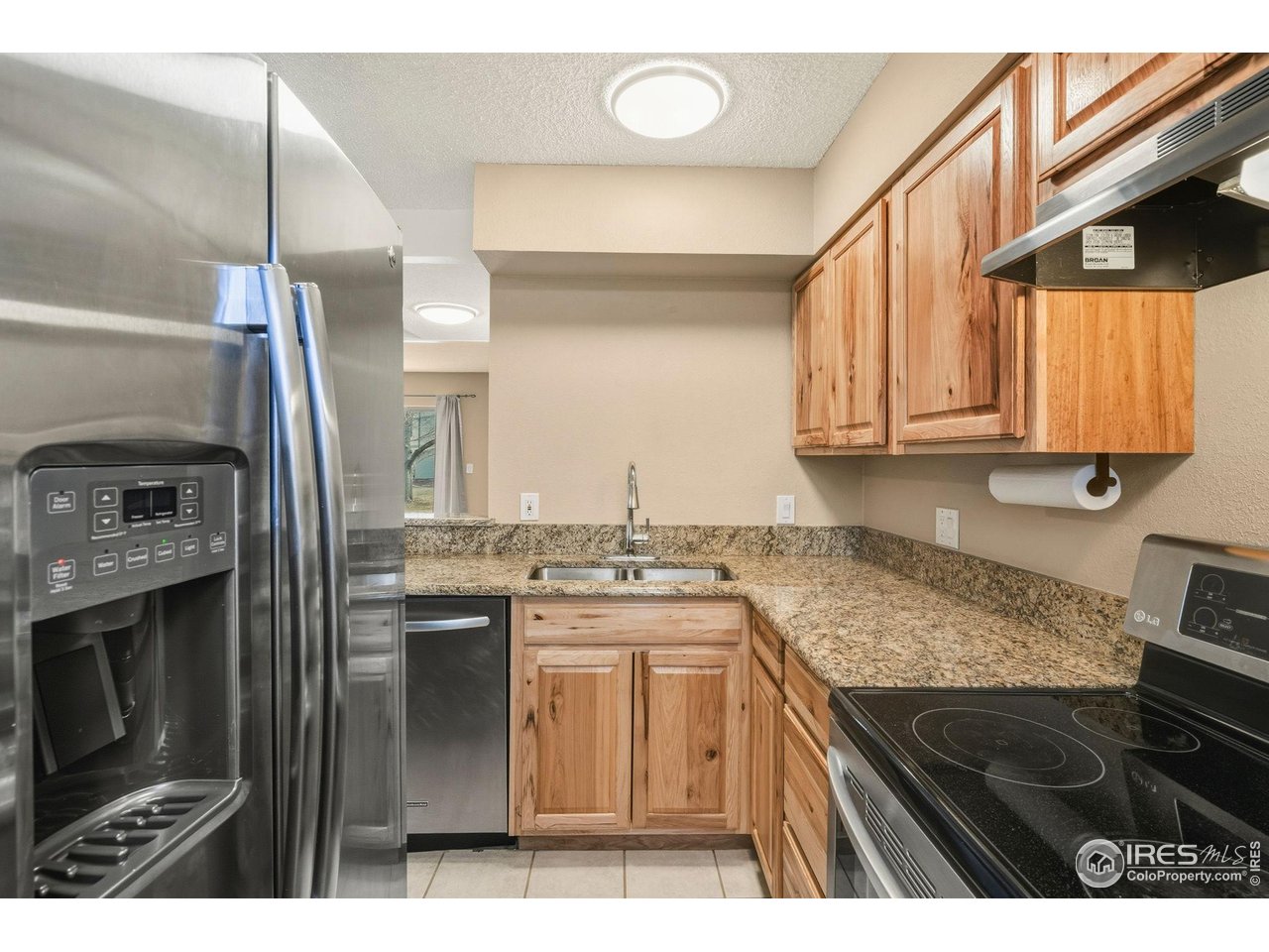 1705 Heatheridge Road, Unit 103 Fort Collins, CO 80526 - Photo 3 of 16 a kitchen with stainless steel appliances granite countertop a stove a sink and a microwave
