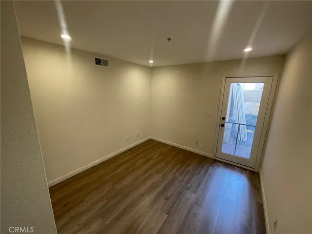 an empty room with wooden floor and mirror