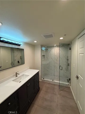 a bathroom with a shower sink and mirror