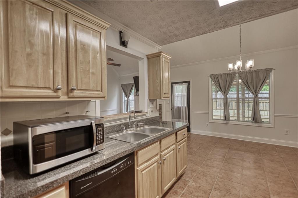 115 Huntington Street Covington, GA 30016 - Photo 14 of 77 a kitchen with granite countertop stainless steel appliances a stove sink and microwave