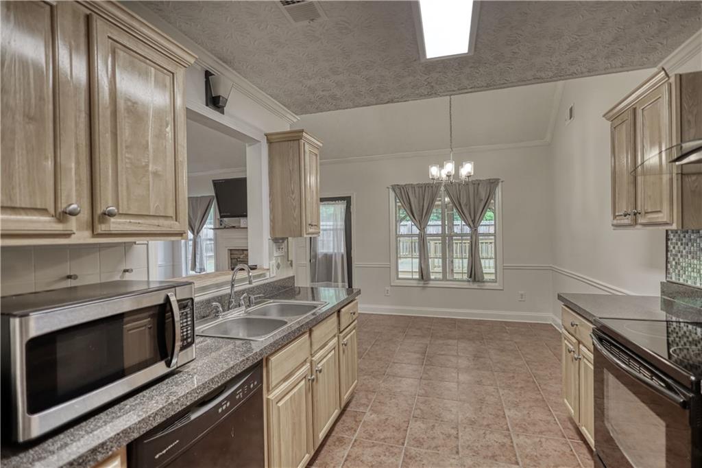 115 Huntington Street Covington, GA 30016 - Photo 17 of 77 a kitchen with granite countertop stainless steel appliances a stove sink and microwave