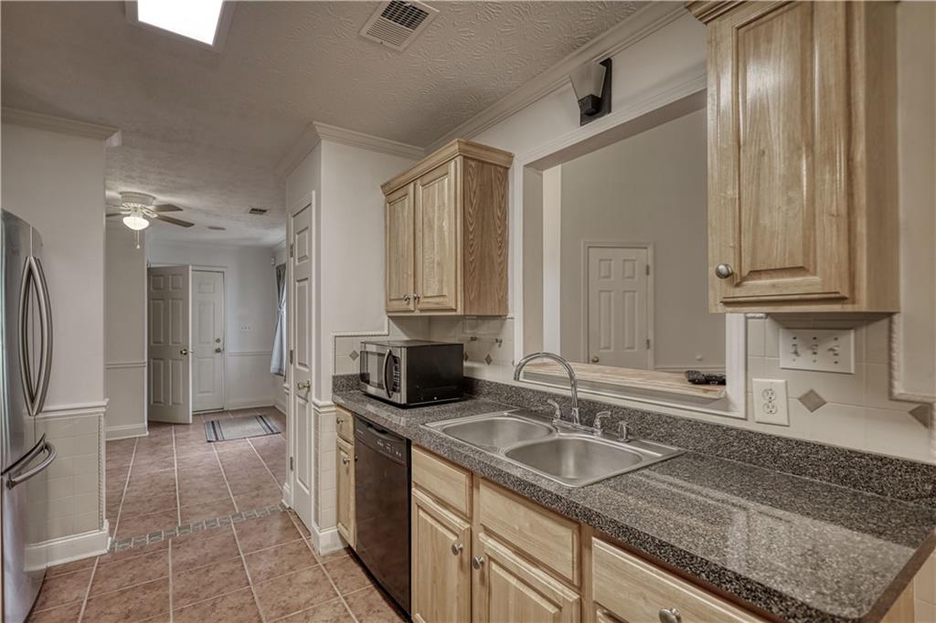 115 Huntington Street Covington, GA 30016 - Photo 20 of 77 a kitchen with stainless steel appliances granite countertop a sink stove and refrigerator