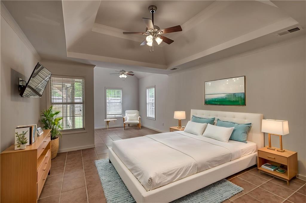 115 Huntington Street Covington, GA 30016 - Photo 26 of 77 a bedroom with a large bed and a chandelier