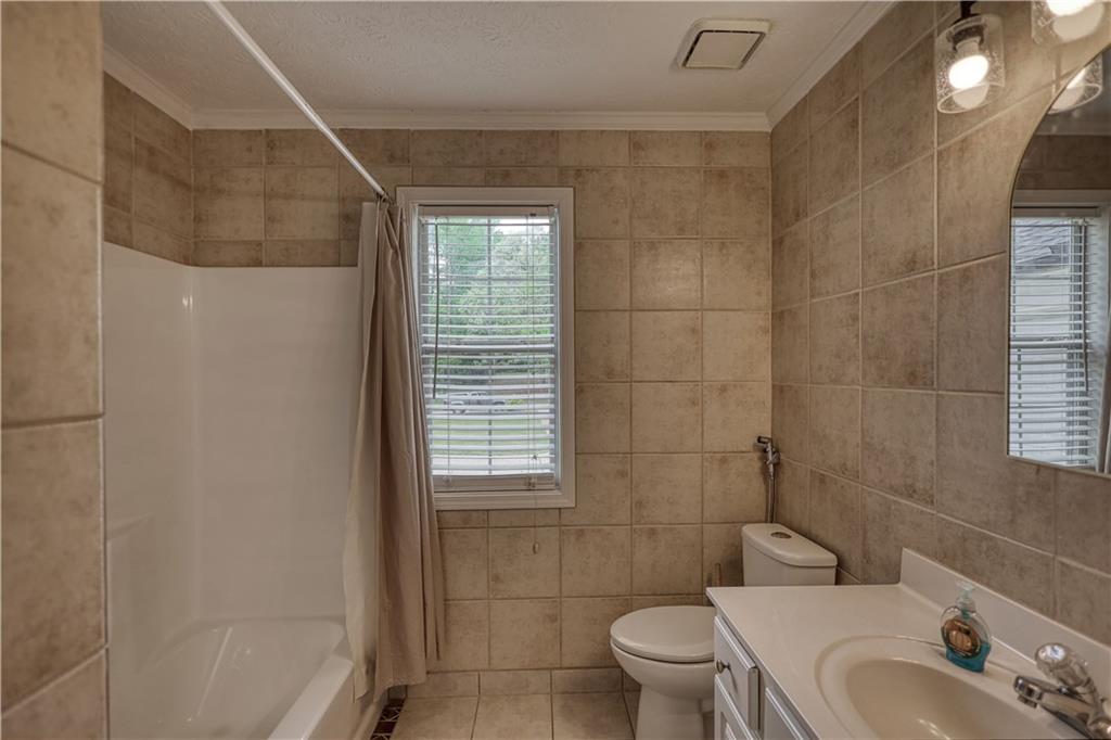 115 Huntington Street Covington, GA 30016 - Photo 40 of 77 a bathroom with a sink a toilet and shower