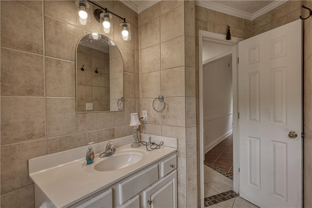 115 Huntington Street Covington, GA 30016 - Photo 43 of 77 a bathroom with a sink shower and a mirror