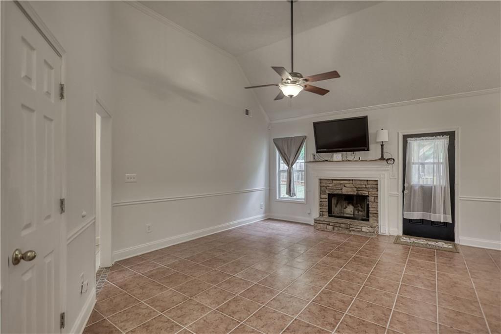 115 Huntington Street Covington, GA 30016 - Photo 8 of 77 a view of a livingroom with a fireplace a ceiling fan a fireplace and windows
