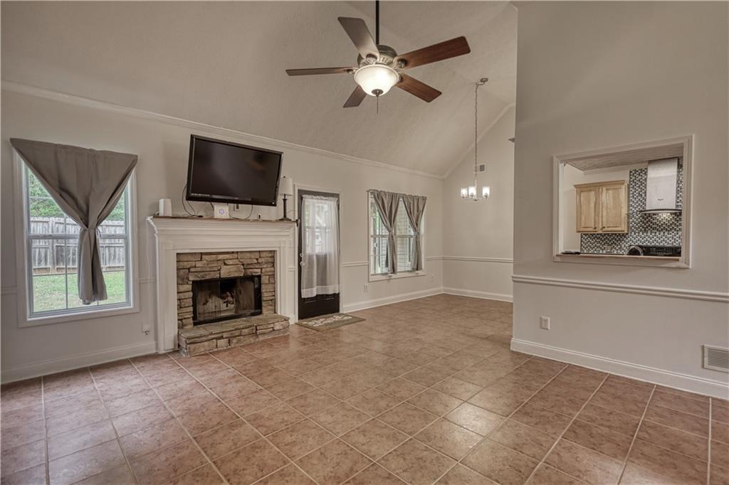 115 Huntington Street Covington, GA 30016 - Photo 9 of 77 a view of an empty room with a kitchen and a fireplace