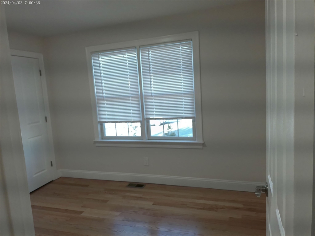 857 Washington Street, Unit 857 Canton, MA 02021 - Photo 11 of 17 an empty room with wooden floor and windows