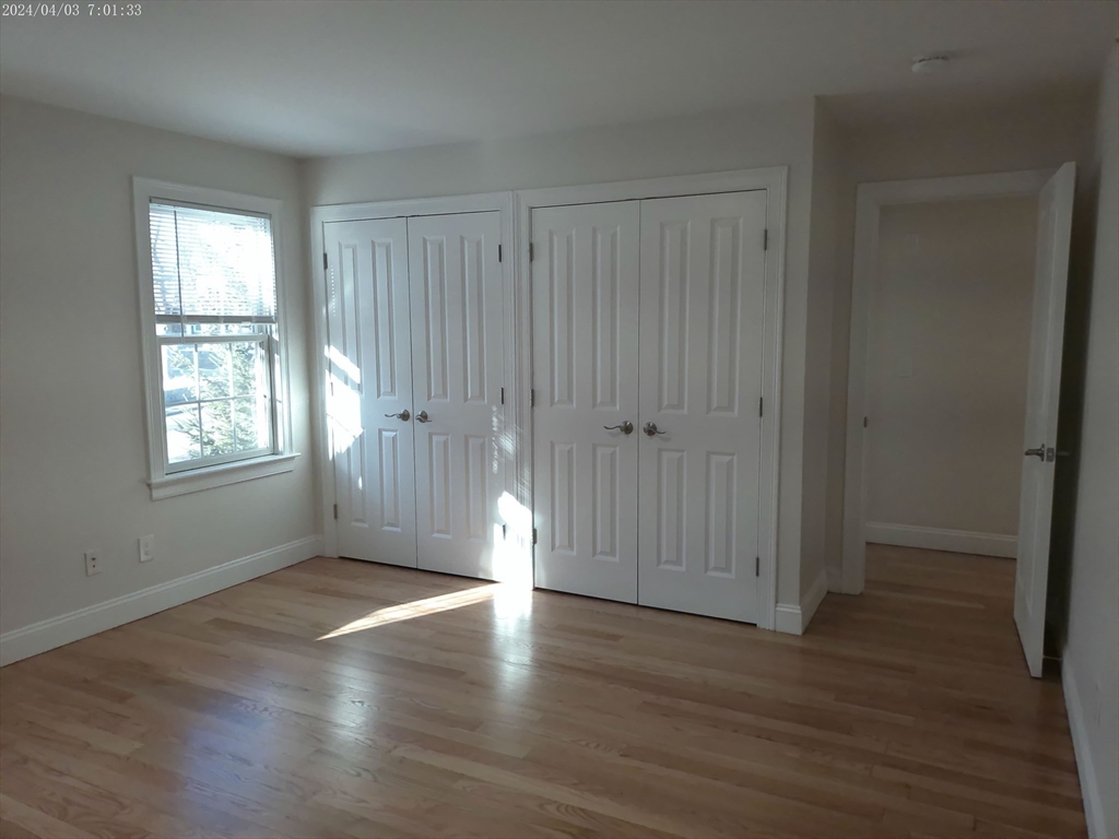 857 Washington Street, Unit 857 Canton, MA 02021 - Photo 13 of 17 an empty room with wooden floor and windows