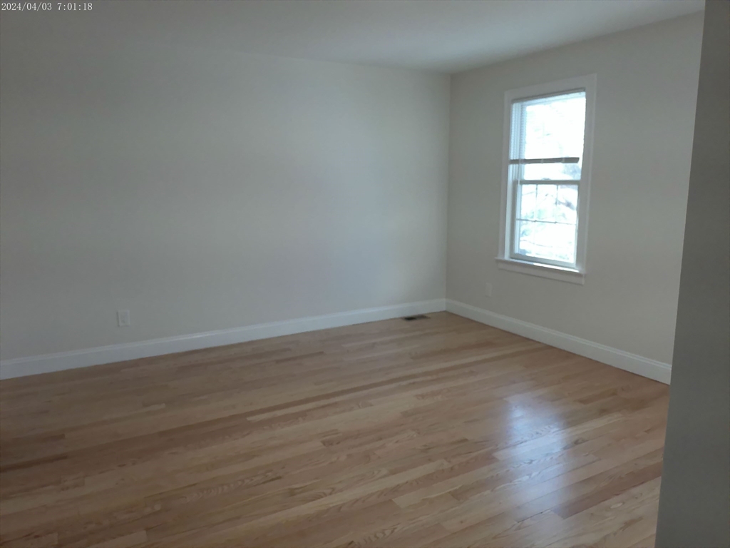 857 Washington Street, Unit 857 Canton, MA 02021 - Photo 14 of 17 an empty room with wooden floor and windows