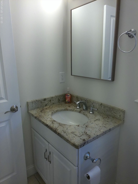 857 Washington Street, Unit 857 Canton, MA 02021 - Photo 10 of 17 a bathroom with a granite countertop sink and a mirror